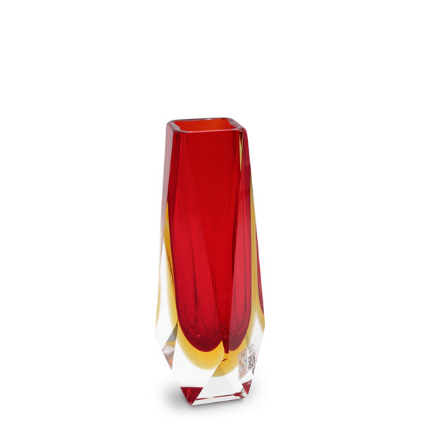 This image features a beautiful piece of Murano glass, specifically a vase. The color palette is rich and warm, with shades of red and yellow that create a vibrant contrast, typical of the traditional Venetian glass-making techniques. The design has intricate details and patterns that add to its visual appeal. The craftsmanship is evident in the way light interacts with the glass, refracting through the different layers and creating depth. This is a characteristic feature of Murano glass, which often involves several layers of molten glass being laid over one another before being blown into shape, resulting in a variety of textures and colors within the same piece. The background is neutral and unobtrusive, allowing the vase to stand out as the focal point. This suggests that the image might be used for commercial or promotional purposes, highlighting the elegance and artistry of Murano glass products. The text 