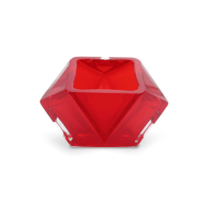 The image depicts a vibrant red glass piece, which appears to be a vase or lamp. The glass has an intricate design that resembles a faceted gemstone with many cuts and angles creating a sparkling effect, giving it a luxurious look. It is crafted in the style of Venetian glass artistry, known for its detailed craftsmanship and vibrant colors. The background is neutral, which highlights the bright red color of the glass piece. The design suggests that this could be a product from Alessandro Mandruzzato, a Murano glass manufacturer. Murano glass is highly sought after for its quality and aesthetic appeal, especially in Italian design circles. The overall appearance of the piece indicates it is likely intended for both functional use as well as decorative display.