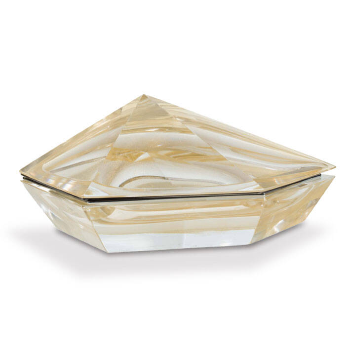 The image shows a piece of Murano glass. This is a type of glass made on the Venetian island of Murano, Italy, known for its distinctive style and techniques that date back centuries. The glass object appears to be a decorative item, possibly a lamp or a vase, with an irregular, triangular shape. It features a translucent, pale yellow color with subtle variations in hues, indicating the use of special glassmaking processes like filigrana, which involves pulling strands of glass through a caneleer, creating intricate patterns within the glass. The craftsmanship is evident in the way light refracts and plays off the surface, highlighting its unique texture and pattern.