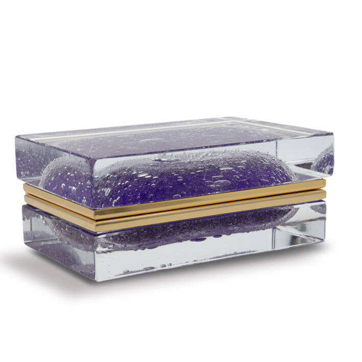 The image features a beautiful piece of Muran glass, specifically from the renowned Alessandro Mandruzzato factory in Venice, Italy. This particular item is a rectangular container with rounded edges and corners, which gives it an elegant and contemporary design. The container's lid has a smooth, reflective surface that suggests it could be made of crystal or clear glass, while the body exhibits a frosted texture with hints of purple color, possibly due to the inclusion of manganese dioxide in the glass. The handle is attached to the body by what appears to be a thin metal band, providing a subtle contrast against the glass's matte finish. This piece showcases the intricate craftsmanship and design skills that are characteristic of Muran glass artisans.