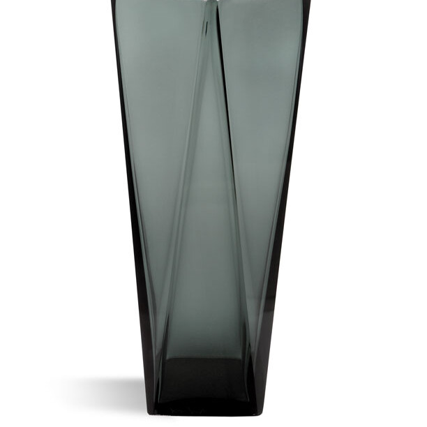 This image features a tall, slender, modern glass vase with a unique design. It has straight sides and angular cuts that give it a geometric yet organic feel. The vase appears to be made of dark-colored glass with a subtle, reflective quality that suggests thickness and durability. The background is neutral, which highlights the vase as the main subject. There's also a color swatch in the upper right corner, indicating what colors the vase might be available in, including shades of brown, black, and gray. The label 