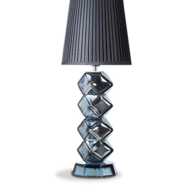 The image features a lamp with a distinctive design, likely made of Murano glass. The lamp stands out with its spiraling shape and what appears to be multiple layers or sections that create an intricate pattern. This type of glass is famous for its quality, craftsmanship, and the way it's handcrafted in Venice, Italy. The style and color variations suggest it could be a piece from Alessandro Mandruzzato, a name known for producing high-quality Murano glass products. The lamp has a base that seems sturdy enough to support the design of the lamp body. Overall, this is an example of luxury home decor with a focus on elegance and sophistication.