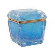 The image displays a piece of Murano glass, which is known for its artisanal glassware. The particular item shown appears to be a blue-colored, cube-shaped object with a frosted interior and a metallic band around the middle. It has an intricate design that includes what seems to be bubbles or trapped air, giving it a textured look on both the inside and outside surfaces. This type of glassware is often associated with Venice, Italy, as Murano is a small island in the Venetian Lagoon that is famous for its glassmaking industry. The craftsmanship suggests that this piece could be used as a decorative item or possibly as part of a collection due to its unique appearance and cultural significance.