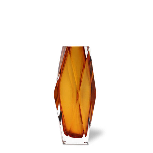 This is an image of a piece of MURAN glass art, specifically from the Alessandro Mandruzzato collection. The vase has an elegant design with a twisted pattern that creates a textured surface. It displays hues of brown and gold, indicative of the traditional Venetian glass making techniques. The craftsmanship is evident in the way the colors blend smoothly across the body of the piece. The background features a beige or light brown color, which contrasts nicely with the vase to highlight its colors and design. The text 