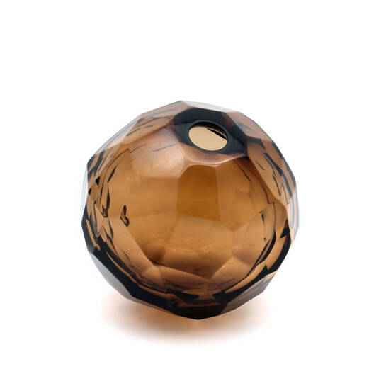 The image shows a round, textured glass object that appears to be crafted with an intricate design. It has a glossy finish and is possibly a piece of Murano glass, known for its vibrant colors and artisanal techniques. The item could be used as a decorative element or perhaps as part of a lamp or vase collection. The style of the image suggests it might have been taken in a studio setting with the intent to showcase the craftsmanship and design details of the object.