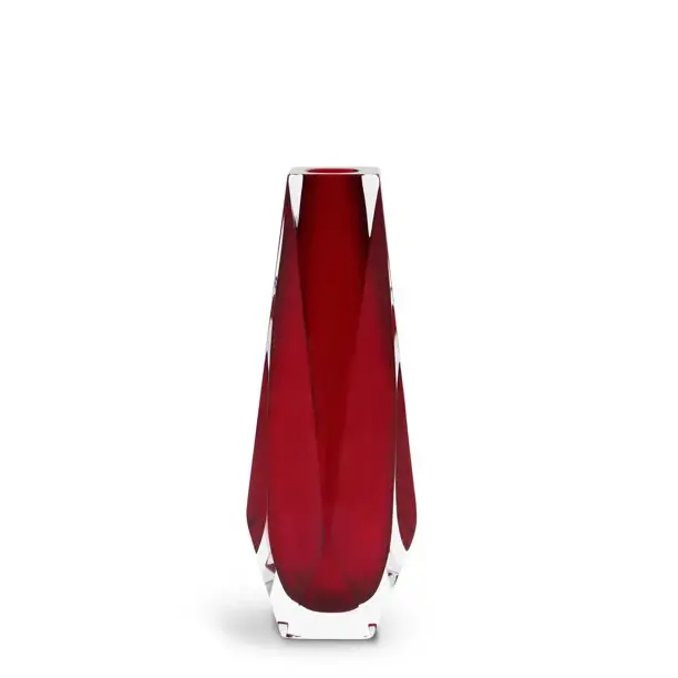 The image displays a vibrant piece of Murano glassware, which is known for its distinctive handcrafted designs. The vase has a deep red color with what appears to be layers or folds that give it a dynamic, almost textured appearance. The design showcases the intricate techniques and artistic expression for which Murano glass is famous. The background features two subtle shades of brown, which complement the rich red of the vase without overwhelming its visual impact. The upper portion of the background has a lighter shade while the lower part is slightly darker, providing a nice contrast that helps the vase stand out as the focal point of the image. This type of glassware is often associated with Italian craftsmanship, particularly from the Venetian island of Murano where it is traditionally made. The craftsmanship of Murano glass is highly valued for its aesthetic appeal and the unique skills required to create such pieces, making them popular in both decorative and collectible contexts.