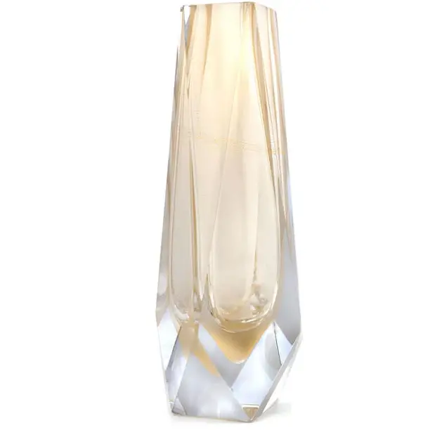 The image showcases a beautifully crafted Murano glass vase. The vase is tall and slender, featuring an elegant design with what appears to be layers or ridges that create a textured effect along its length. It has a light color palette, predominantly in shades of gold and clear, which suggests it could be made from a type of glass known as 