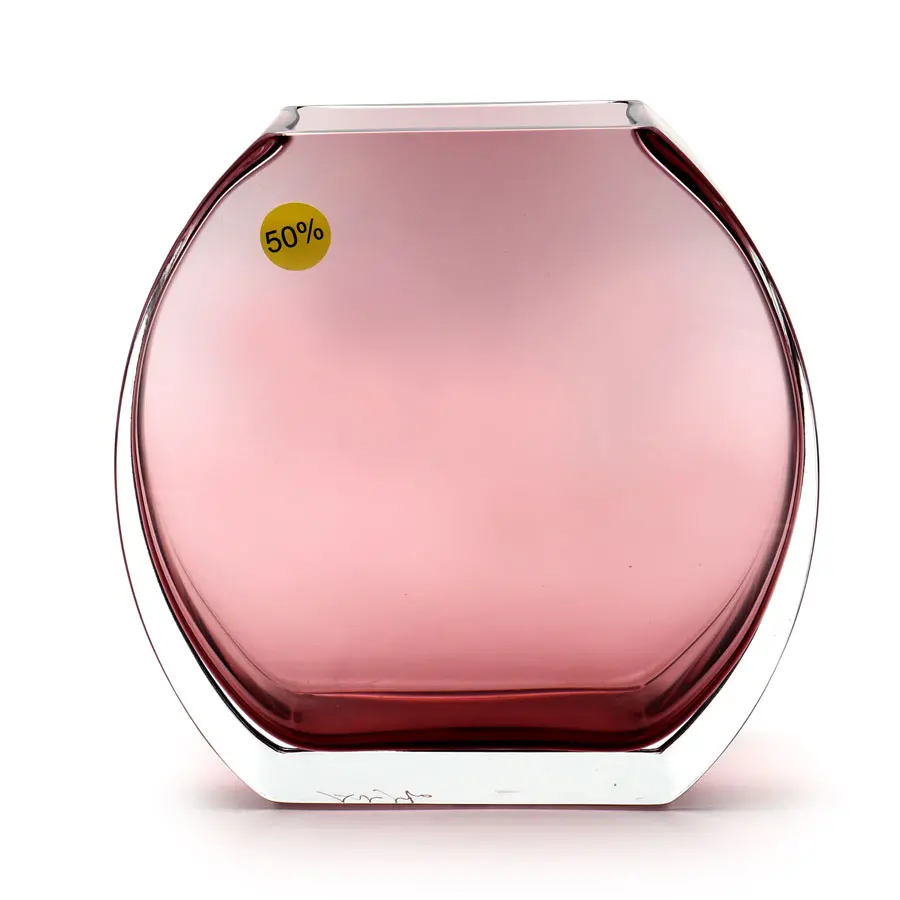 The image shows a piece of Murano glass, specifically a perfume bottle. It has a modern design with a tall, slender shape and a wider base, giving it stability. The body of the bottle is tinted in a soft pink color that appears to be uniform throughout. At the top of the bottle, there's a silver-colored lid or cap, which contrasts nicely with the pink hue of the glass. On the side of the image, there is a tag indicating a discount price of 50% off, suggesting that this item is on sale. The text 